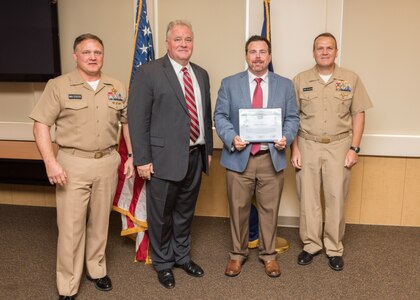 PANAMA CITY, Florida - Randall Whitehead is presented the Warfare Center United States Marine Corps Collaboration Team Award by Commander, Naval Surface Warfare Center Rear Adm. Tom Anderson, USN, Sept. 6, 2018. Pictured from left to right: NSWC Panama City Division (PCD) Commanding Officer Capt. Aaron Peters, USN, NSWC PCD Technical Director Ed Stewart (SES), Randall Whitehead, Rear Adm. Tom Anderson, USN. U.S. Navy photo by Anthony Powers