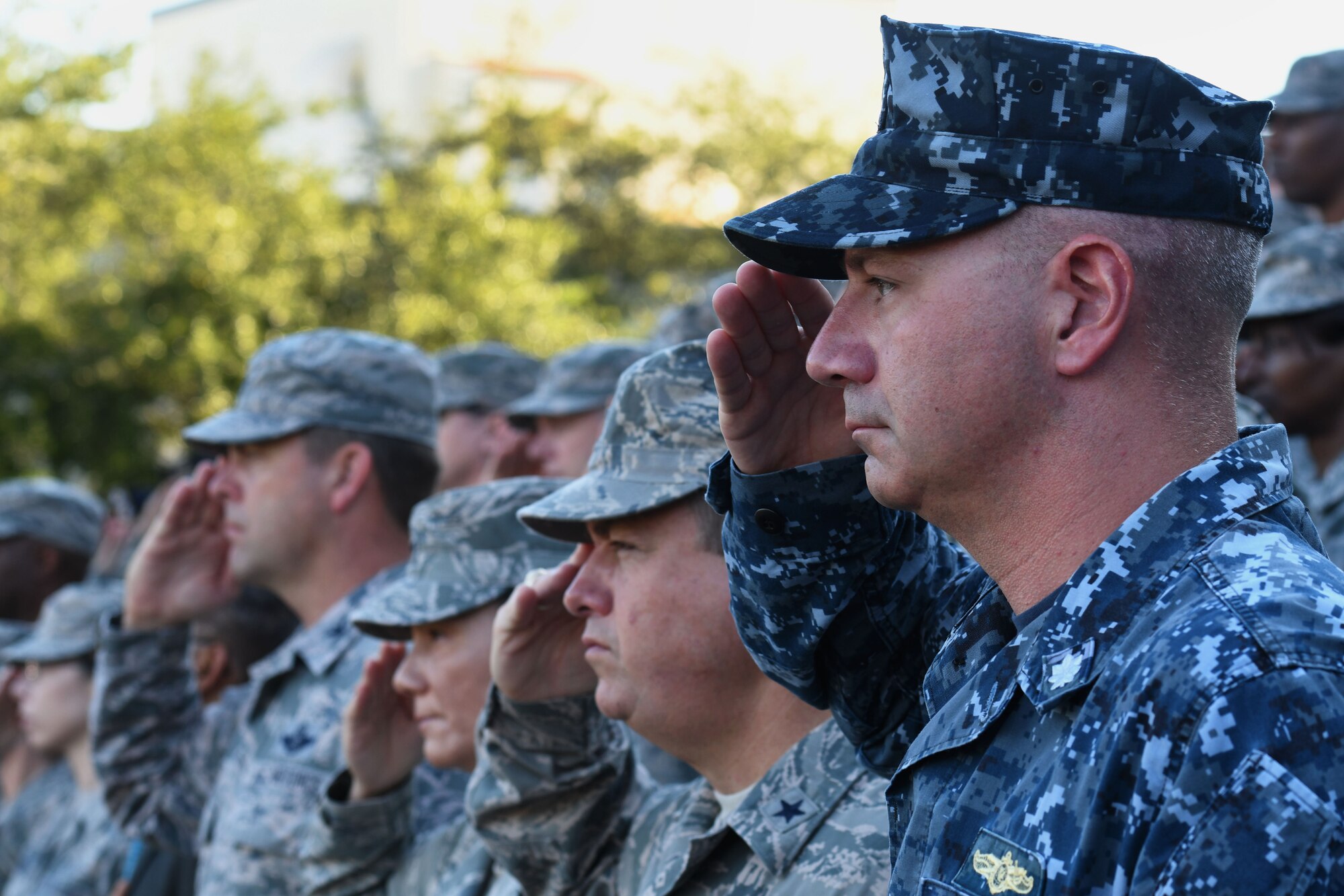 U.S. Navy Cmdr. Timothy Knapp, Center for Naval Aviation Technical Training Unit Keesler commanding officer, and other Keesler leadership render a salute during a 9/11 ceremony in front of the 81st Training Wing headquarters building at Keesler Air Force Base, Mississippi, Sept. 11, 2018. The event honored those who lost their lives during the 9/11 attacks. (U.S. Air Force photo by Kemberly Groue)