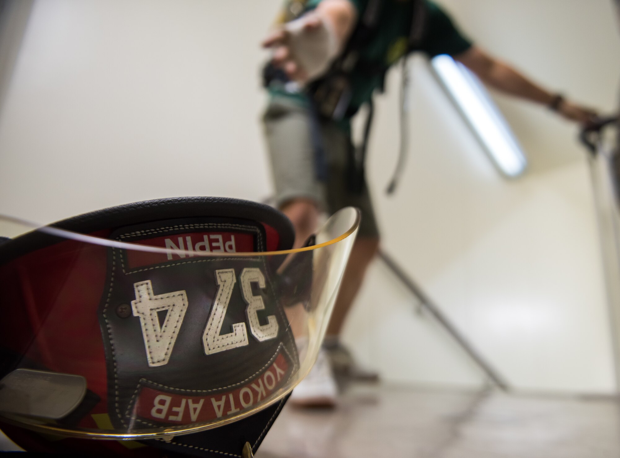 A tower run participant releases a dog-tag into a fire fighter's helmet