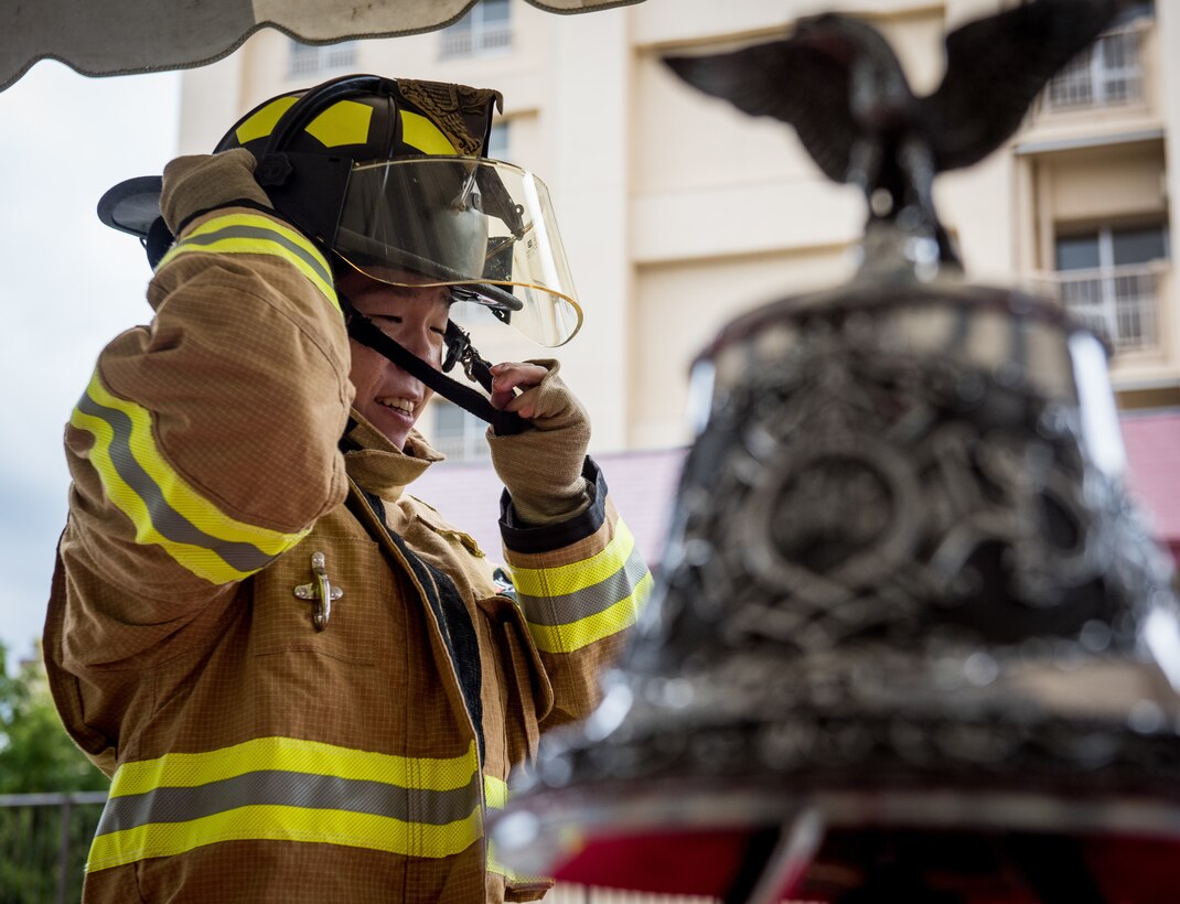A Japanese Firefighter dons a fire helmet