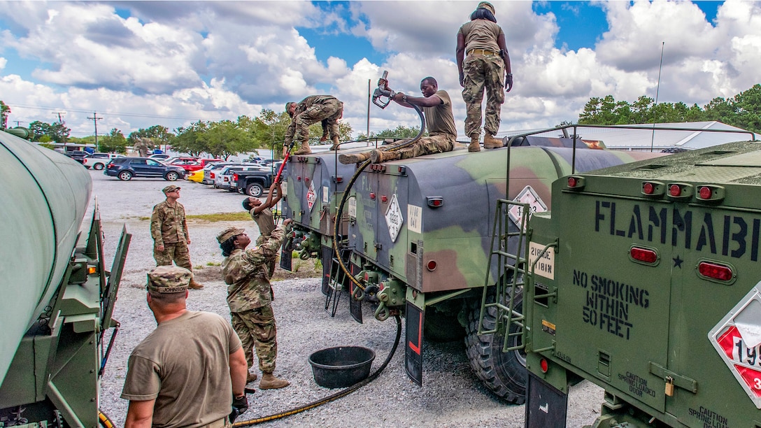 South Carolina National Guardsmen transfer diesel fuel into tanker trucks.