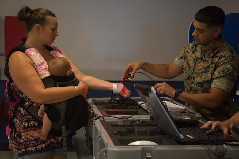 KADENA AIR BASE, OKINAWA, Japan – A Marine scans identification wrist bands during a noncombatant evacuation operations training exercise Aug. 6 at the Samurai Terminal on Kadena Air Base, Okinawa, Japan.