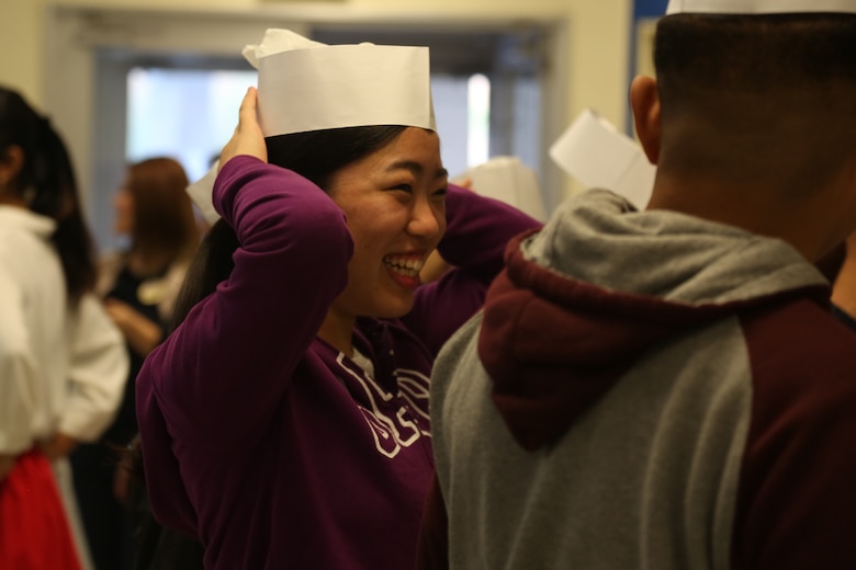 CAMP COURTNEY, OKINAWA, Japan – A high school student from the local community laughs while putting on a cook’s hat during Camp Courtney’s Summer English class Aug. 16 at the Camp Courtney Mess Hall, Okinawa, Japan.