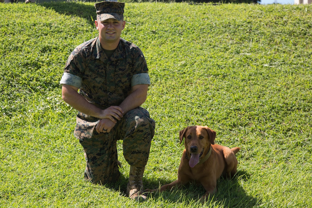 CAMP HANSEN, OKINAWA, Japan – Cpl. Alex Marquissee and military working dog Gage pose for a photo Aug. 31 at the kennels on Camp Hansen, Okinawa, Japan.