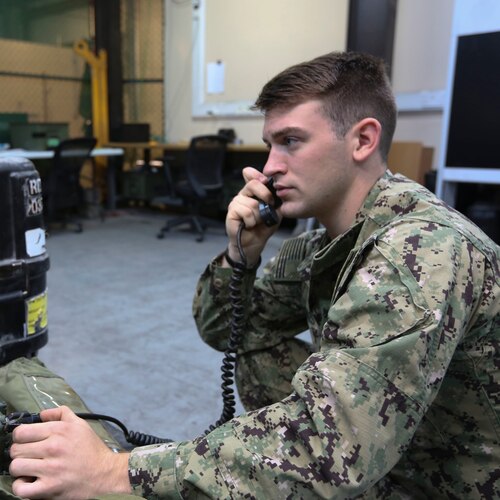 A sailor uses a radio.
