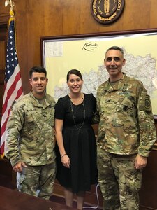 Woman standing with two Soldiers in uniform.