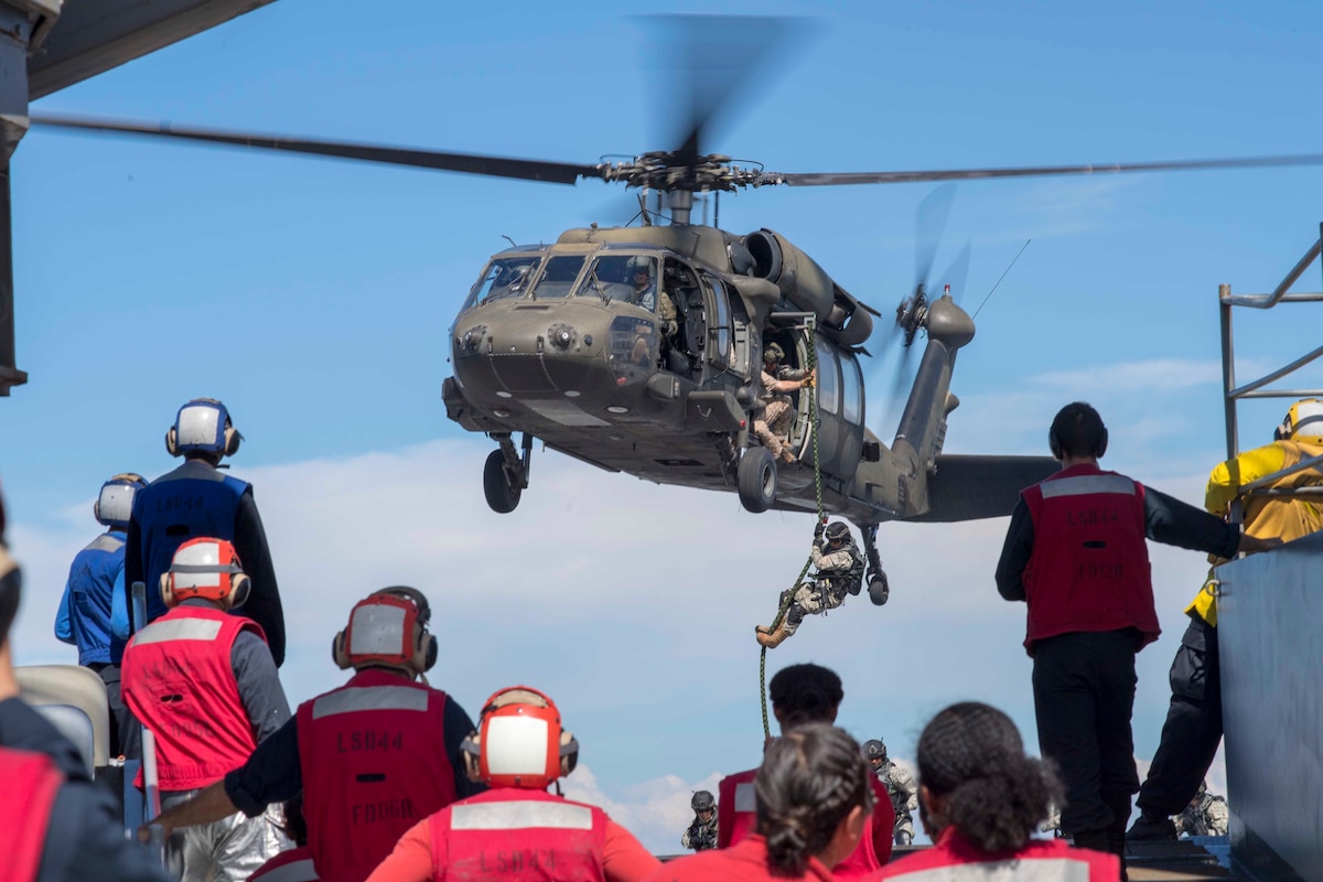 Colombian Marines fast-rope from a helicopter onto the flight deck of USS Gunston Hall (LSD 44) during UNITAS 2018.