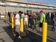 High school students with uniformed Soldier at NHRA event.