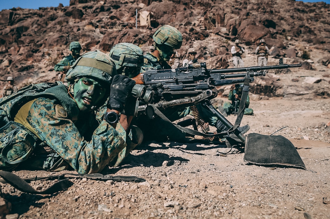 Singapore Guardsmen provide machine gun support for a ground assault on Range 400 during Valiant Mark 2018 aboard the Marine Corps Air Ground Combat Center, Twentynine Palms, Calif., Sept. 5, 2018. Valiant Mark is an annual exercise conducted by U.S. Marines and the Singapore Armed Forces designed to facilitate increased interoperability and strengthen military-to-military relationships through combined-arms integration skills training. (U.S. Marine Corps photo by Lance Cpl. William Chockey)