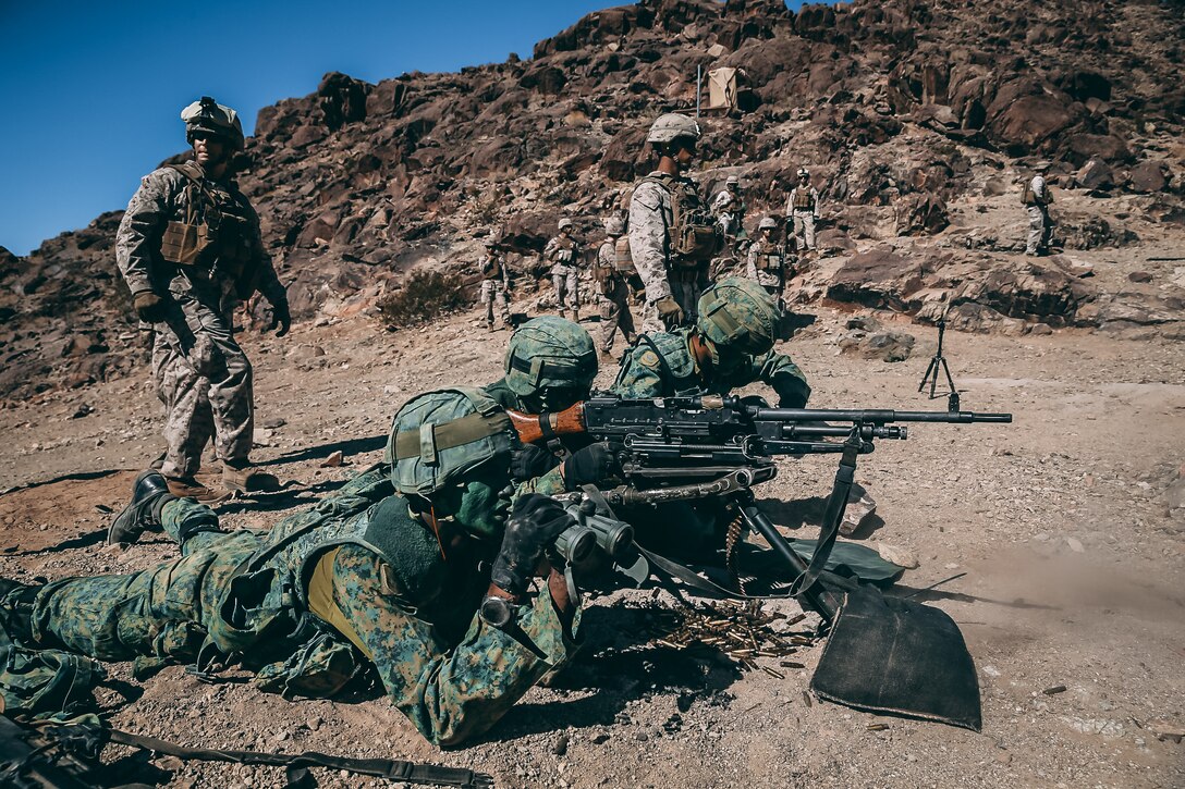 Singapore Guardsmen provide machine gun support for a ground assault on Range 400 during Valiant Mark 2018 aboard the Marine Corps Air Ground Combat Center, Twentynine Palms, Calif., Sept. 5, 2018. Valiant Mark is an annual exercise conducted by U.S. Marines and the Singapore Armed Forces designed to facilitate increased interoperability and strengthen military-to-military relationships through combined-arms integration skills training. (U.S. Marine Corps photo by Lance Cpl. William Chockey)