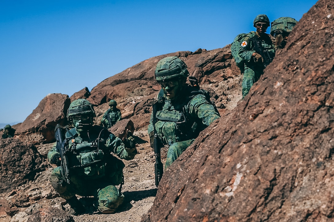 Singapore Guardsmen wait for their supportive machine gun fire before crossing the danger area for a ground assault on Range 400 during Valiant Mark 2018 aboard the Marine Corps Air Ground Combat Center, Twentynine Palms, Calif., Sept. 5, 2018. Valiant Mark is an annual exercise conducted by U.S. Marines and the Singapore Armed Forces designed to facilitate increased interoperability and strengthen military-to-military relationships through combined-arms integration skills training. (U.S. Marine Corps photo by Lance Cpl. William Chockey)