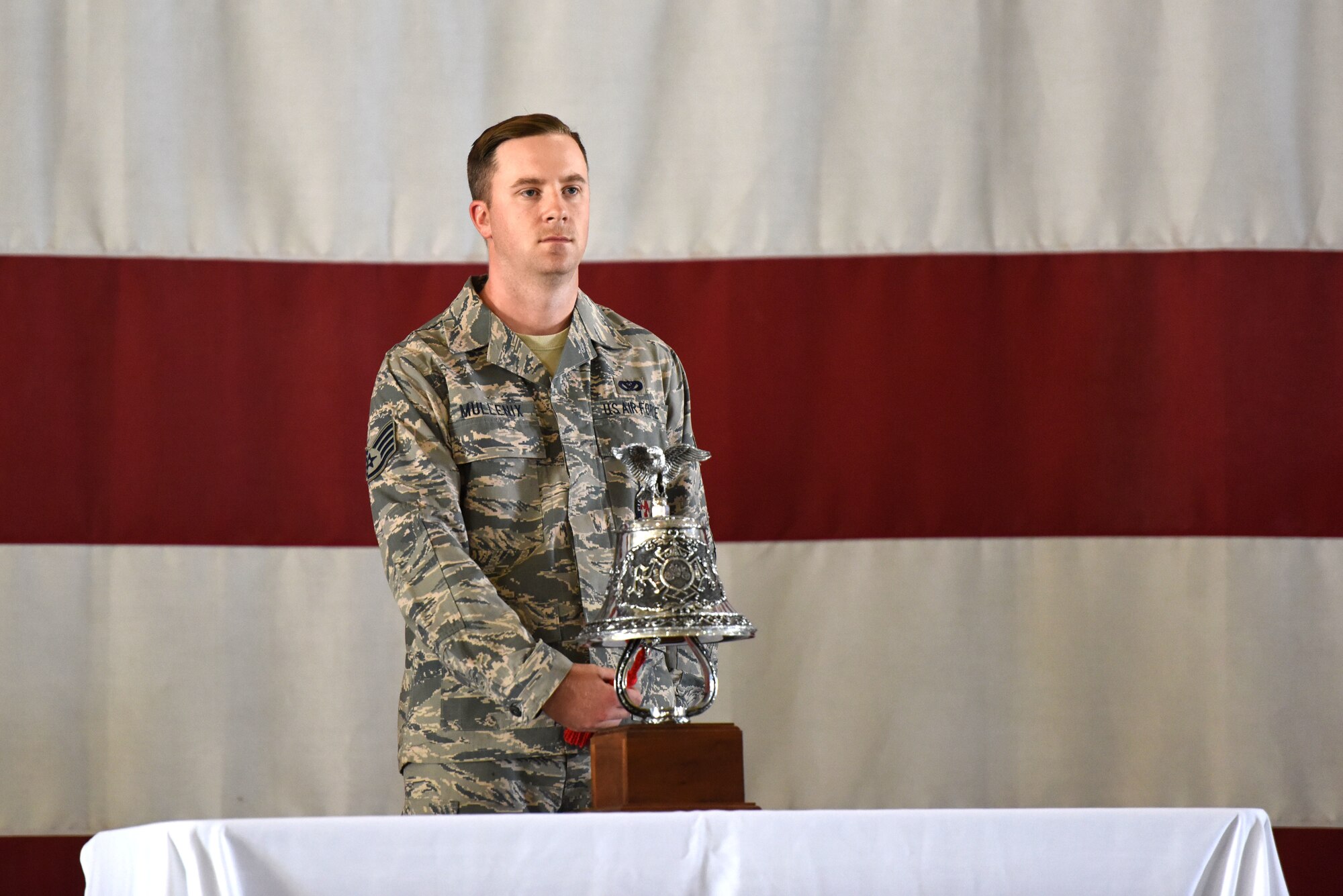 U.S. Air Force Staff Sgt. James Mullenix, 312th Training Squadron instructor, rings a bell five times, three times in a row, to signal the end of watch, according to firefighter tradition in honor of the firefighters who lost their lives on Sept. 11, 2001 during a 9/11 memorial service at the Louis F. Garland Department of Defense Fire Academy on Goodfellow Air Force Base, Sept. 11, 2018. Before the ringing of the bell, there was a reading of the timeline of events that happened on 9/11. (U.S. Air Force photo by Airman 1st Class Seraiah Hines/Released)