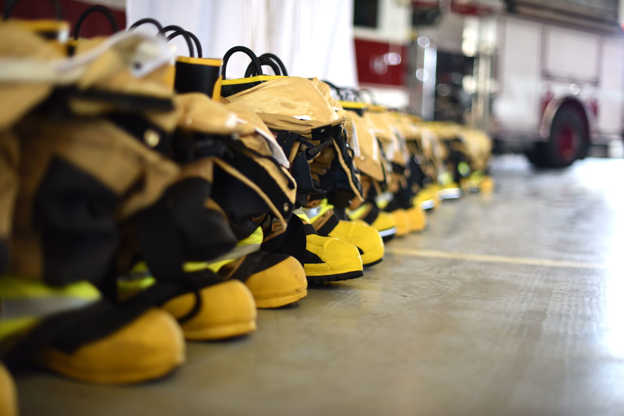 A line of firefighting equipment in front of a podium during a 9/11 memorial service at the Louis F. Garland Department of Defense Fire Academy serves as a reminder of those who gave the ultimate sacrifice on Goodfellow Air Force Base, Texas, Sept. 11, 2018. Goodfellow members came together to remember and honor those who died 17 years ago when answering the call to help. (U.S. Air Force photo by Airman 1st Class Seraiah Hines/Released)