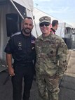 Two men - one uniformed Soldier and Tony Schumacher, race car driver.