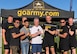 Eight men standing in front of Army tent.