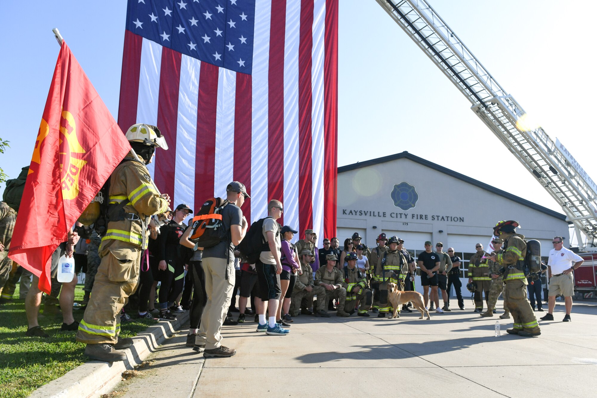 Staff Sgt. Caleb Saunders (far right), from the 775th Civil Engineering Squadron Fire Department, reads about one of the 9/11 fallen at the Kaysville Fire Station during one of the stops of the 9/11 Memorial Ruck March.