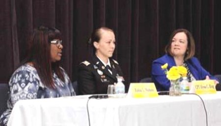 Three women sitting at discussion table.