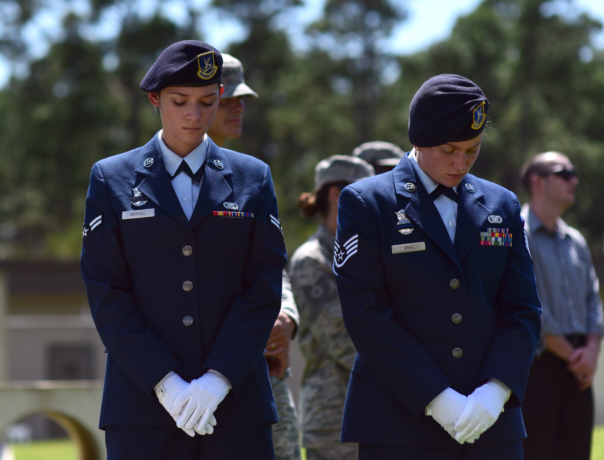 U.S. Air Force Airman 1st Class Arleen Michael, left, and Staff Sgt. Katelyn Grau, right, 325th Security Forces Squadron Airmen, show reverence during a military working dog (MWD) memorial service at Tyndall Air Force Base, Fla., Sept. 7, 2018. Jack, a Belgian Malinois, was an explosives and patrol dog who shared a special bond with his handlers. MWDs are afforded military customs and courtesies. (U.S. Air Force photo by Senior Airman Isaiah J. Soliz)
