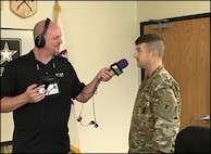 Two men, one is radio broadcaster and one is uniformed Soldier.