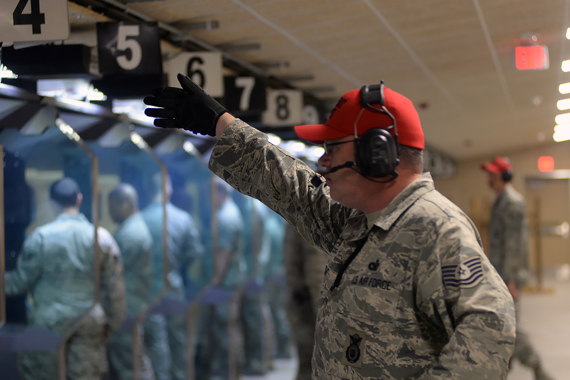 Tech. Sgt. Brian Stuart, 55th Security Forces Squadron (SFS) combat arms NCO in charge, gives the all clear signal after a round of shots are fired during an Excellence in Competition (EIC) pistol contest Aug. 30, 2018, at Offutt Air Force Base, Nebraska. This is the second EIC event the 55th SFS has had since completing the renovations of their combat arms shooting range earlier this year. The first focused on the use of rifles. (U.S. Air Force photo by Kendra Williams)