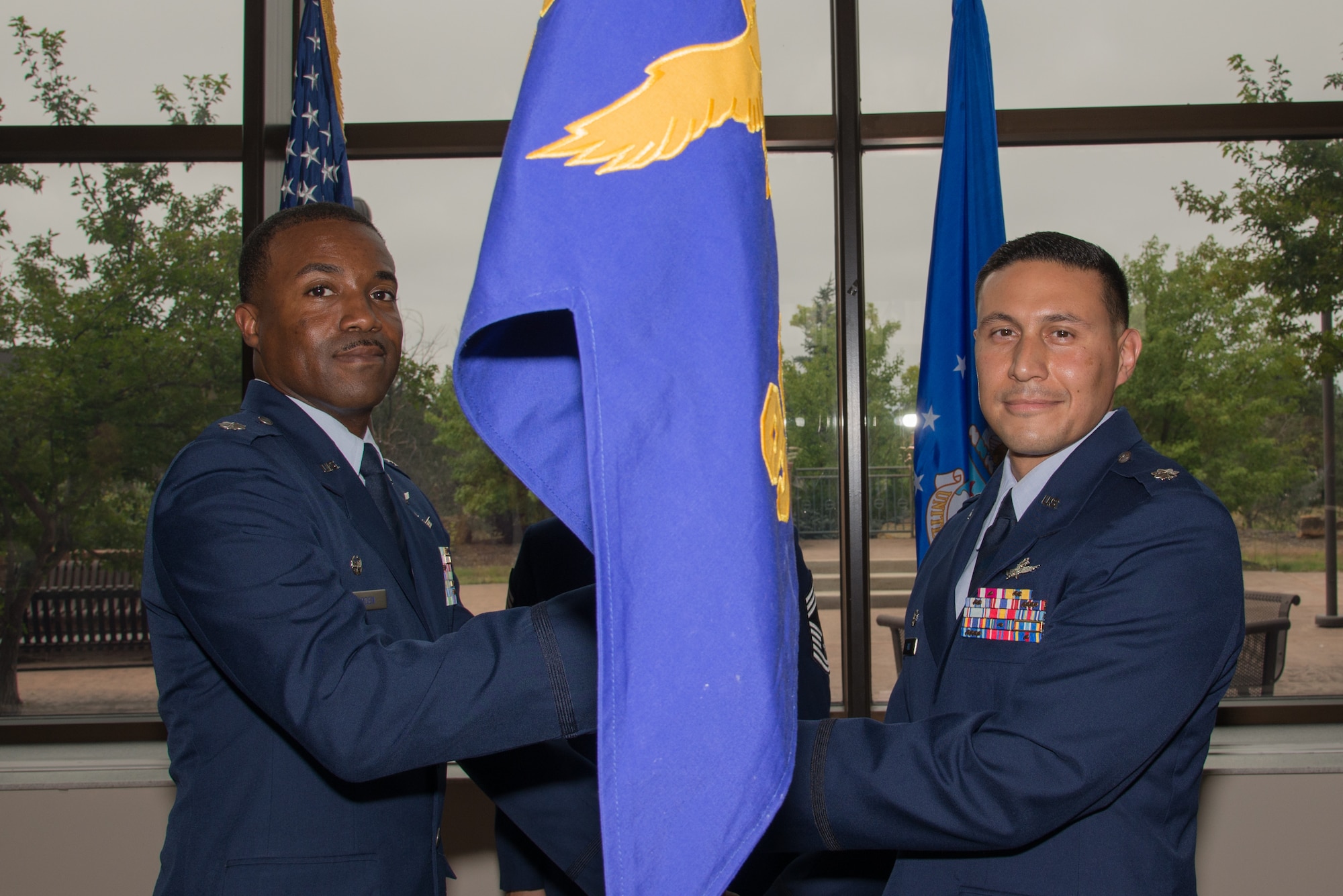 Lt. Col. Silas Darden, left, the 960th Cyberspace Operations Group Detachment 2 commander, passes the 960th NOS guidon to Lt. Col. Fernando Ruiz as he takes command of the squadron during a change of command ceremony at Peterson Air Force Base, Colorado, Sept. 8, 2018.