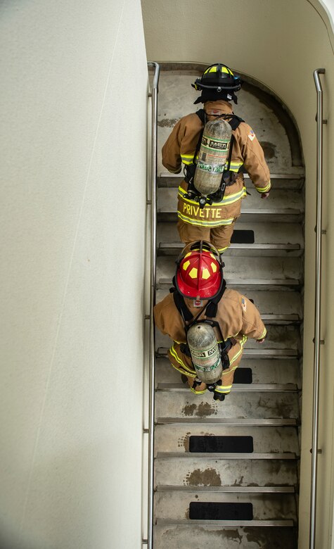 U.S. Air Force Senior Airman Forrest Privette, top, 18th Civil Engineer Squadron driver operator, and Staff Sgt. Nicholas Schafer, 18th CES lead firefighter, walk up a flight of stairs during the Kadena Fire Emergency Services 9/11 Memorial Stair Climb Sept. 11, 2018, at Kadena Air Base, Japan. Firefighters participating in the event donned approximately 60 pounds of gear and climbed a total of 110 flights of stairs to simulate the climb firefighters made during the Sept. 11, 2001, terrorist attacks at the World Trade Center in N.Y.  (U.S. Air Force photo by Staff Sgt. Micaiah Anthony)