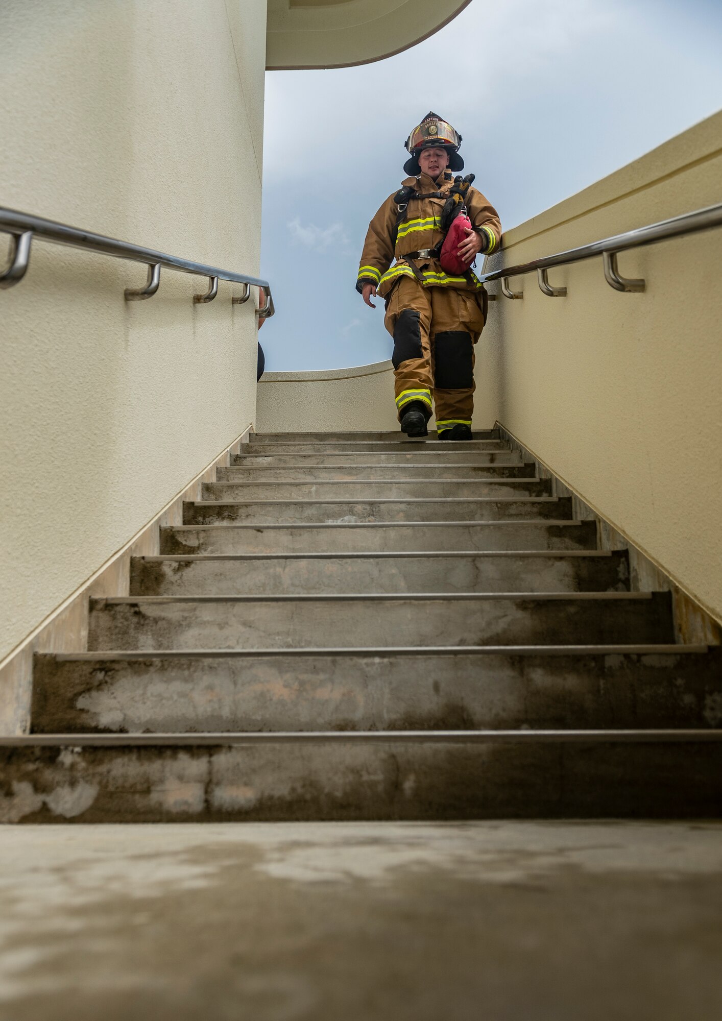 U.S. Air Force Staff Sgt. Nicholas Schafer, 18th Civil Engineer Squadron lead firefighter, walks down a flight of stairs during the Kadena Fire Emergency Services 9/11 Memorial Stair Climb Sept. 11, 2018, at Kadena Air Base, Japan. Firefighters participating in the event donned approximately 60 pounds of gear and climbed a total of 110 flights of stairs to simulate the climb firefighters made during the Sept. 11, 2001, terrorist attacks at the World Trade Center in N.Y.  (U.S. Air Force photo by Staff Sgt. Micaiah Anthony)