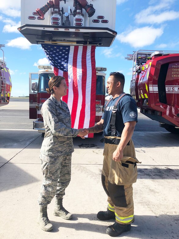 U.S. Air Force Col. Athanasia Shinas, commander of the Air Force Reserve’s 624th Regional Support Group, coins and thanks Tech. Sgt. Justin Sabio for his service as a firefighter following a 9/11 Remembrance Ceremony at the Hickam Field Fire Department at Joint Base Pearl Harbor-Hickam, Hawaii, Sept. 11, 2018. Sabio works full time with the Navy Federal Fire as an advanced emergency medical technician and serves part-time as a firefighter with the 624th Civil Engineer Squadron. (U.S. Air Force photo by Master Sgt. Theanne Herrmann)