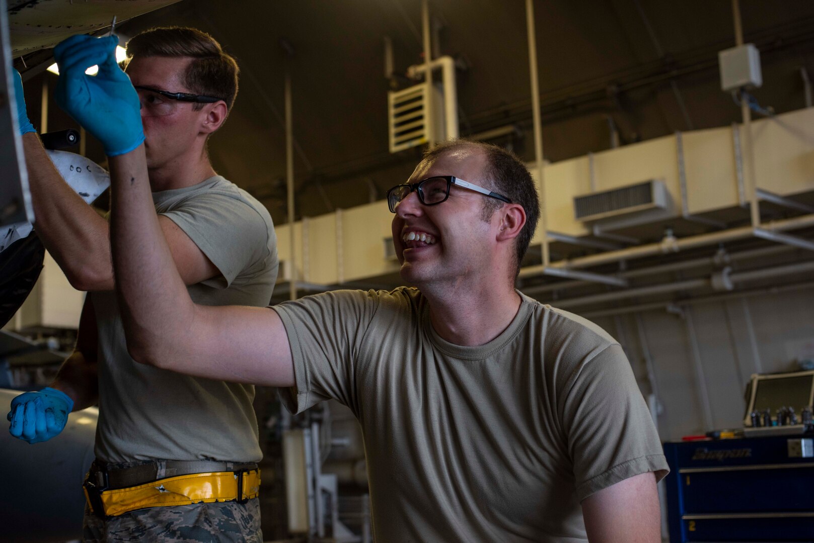 U.S. Air Force Tech. Sgt. Jordon Jones, a 35th Maintenance Squadron aircraft structural maintenance craftsman, smiles while repairing the sheet metal of an F-16 Fighting Falcon at Misawa Air Base, Japan, Aug. 24, 2018. The team discovered corrosion on the lower skin of the aircraft, making it inoperable until repair. Typically the repair would be performed by either depot-level maintainers or contractors, however, the F-16 System Program Office at Hill Air Force Base approved Misawa Airmen to rectify the issue. (U.S. Air Force Airman 1st Class Collette Brooks)