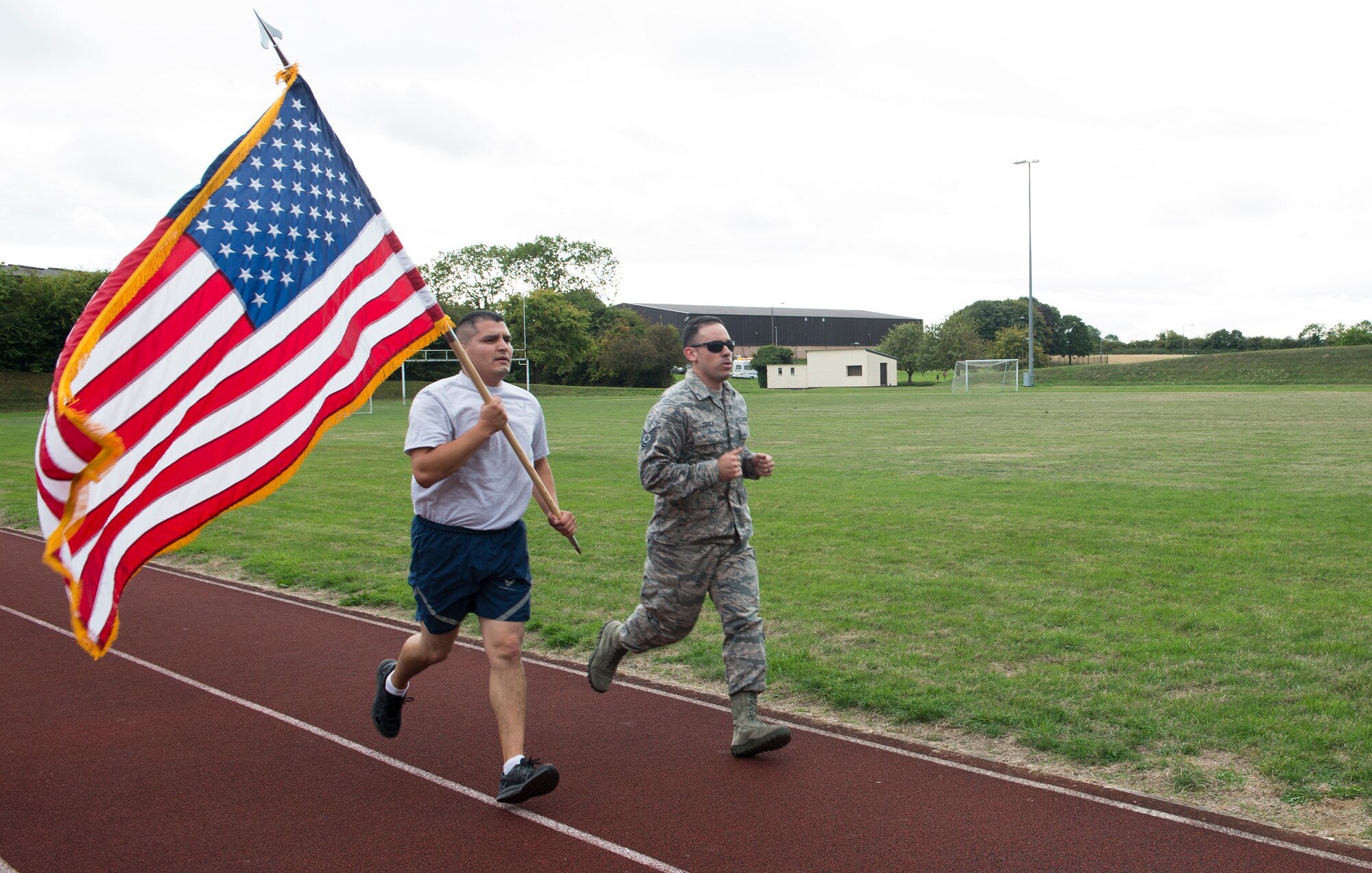 Airmen run and carry the United States flag in honor of the fallen of Sept. 11 at RAF Croughton, United Kingdom, Sept. 11, 2018. The U.S. flag was always carried by various base agencies throughout the day. (U.S. Air Force photo by Senior Airman Chase Sousa)