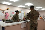 Soldiers review paperwork at a field hospital.