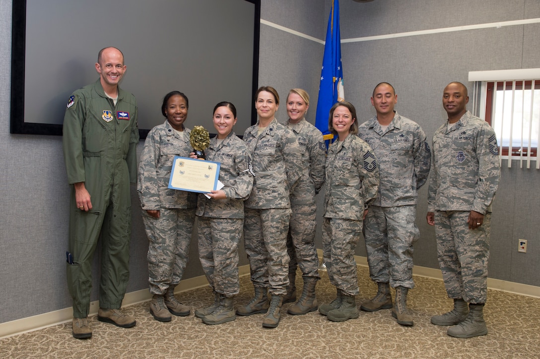 Brig. Gen. E. John Teichert, 412th Test Wing commander (far left), and Chief Master Sgt. Roosevelt Jones, 412th TW command chief (far right), join 412th Medical Support Squadron staff for a photo after Staff Sgt. Delores Otte was presented with a promotion certificate to technical sergeant Sept. 10. Otte was promoted through the Stripes for Exceptional Performance program, which recognizes and promotes outstanding Airmen. (U.S. Air Force photo by Joseph Pol Sebastian Gocong)