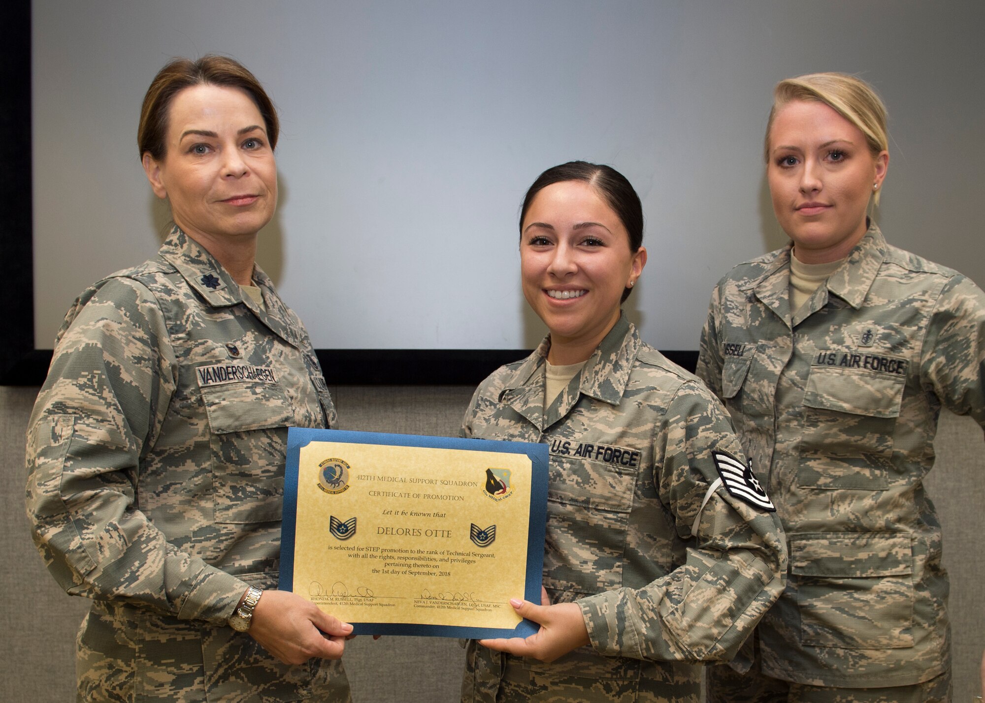 Brig. Gen. E. John Teichert, 412th Test Wing commander (far left), and Chief Master Sgt. Roosevelt Jones, 412th TW command chief (far right), join 412th Medical Support Squadron staff for a photo after Staff Sgt. Delores Otte was presented with a promotion certificate to technical sergeant Sept. 10. Otte was promoted through the Stripes for Exceptional Performance program, which recognizes and promotes outstanding Airmen. (U.S. Air Force photo by Joseph Pol Sebastian Gocong)