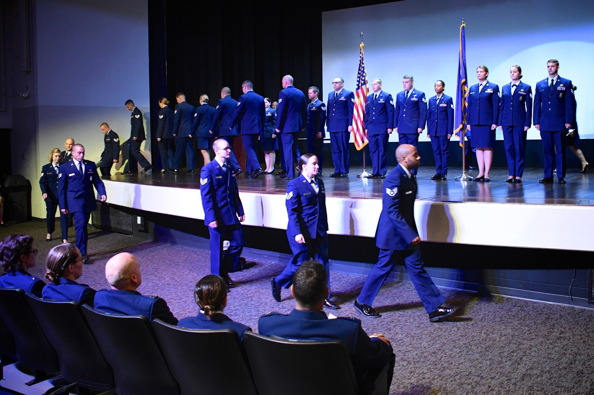 Members of the 932nd Airlift Wing walk past the American flag and Air Force flag at the start of the unit's Non-Commissioned and Senior Non-Commissioned Officer Induction Ceremony held September 9, 2018, at Scott Air Force Base, Illinois.  Friends, family, and co-workers cheered as the new inductees walked up to collect their promotion certificates from the commander of the wing, Col. Raymond Smith, and the Command Chief, Chief Master Sgt. Barbara Gilmore.  The event recognized the leadership and skills of those members achieving higher ranks and leadership expectation status recently.  (U.S. Air Force photo by Lt. Col. Stan Paregien)