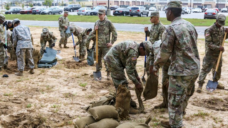 Soldiers fill sandbags.