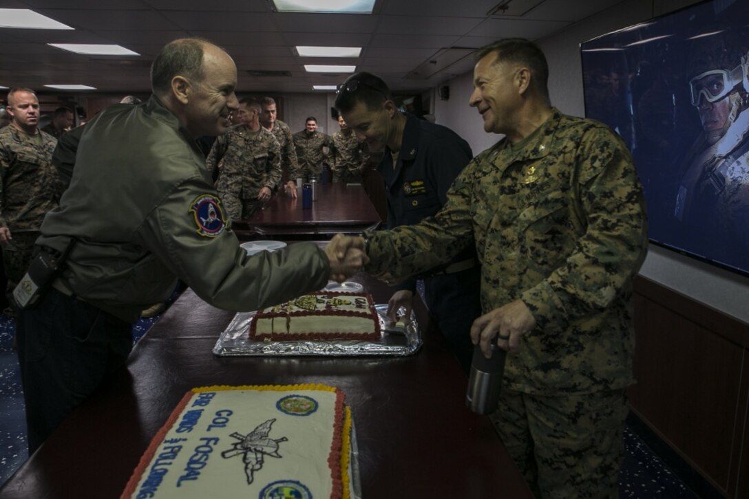 Col. Scott Fosdal, Expeditionary Operations Training Group senior evaluator, shakes hands with Marines and Sailors during a celebration honoring his retirement aboard the amphibious assault ship USS Wasp (LHD 1), off the coast of Okinawa, Japan, Sep. 3, 2018.