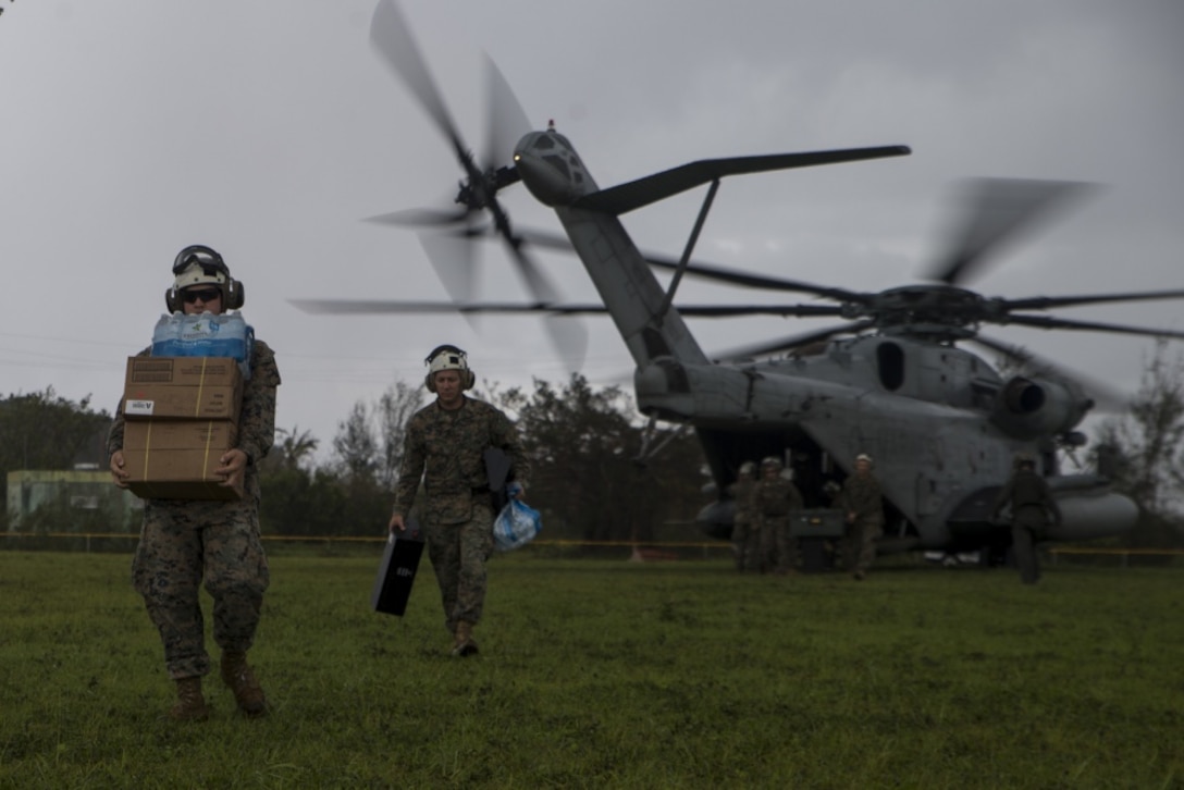Marines with Combat Logistics Battalion 31 carry supplies from a CH-53E Super Stallion with Marine Medium Tiltrotor Squadron 262 (Rein.) during typhoon relief efforts in Rota, Northern Mariana Islands, Sept. 11, 2018.