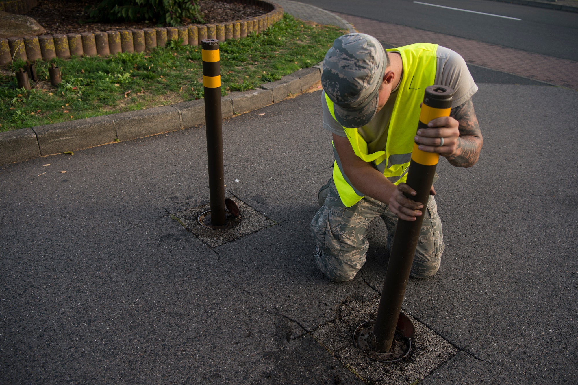 U.S. Air Force Airman 1st Class Chance Sturgeon, 52nd Civil Engineer Squadron Pavement and Construction equipment operator, places a barrier pole in a roadway at Spangdahlem Air Base, Germany, Sept. 10, 2018, during a base-wide readiness exercise. Barriers are used to protect facilities and personnel in the event of a base intrusion. The exercise stressed the importance of response, readiness, and resiliency. (U.S. Air Force photo by Airman 1st Class Valerie Seelye)