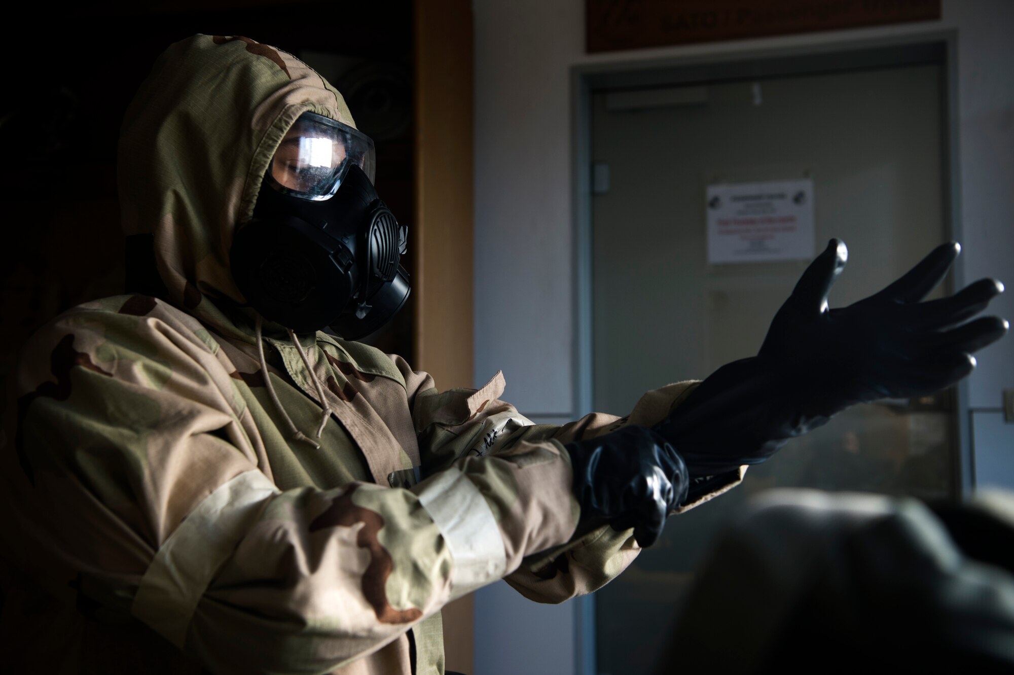 U.S. Air Force Airman 1st Class Joshua Bisch, 52nd Logistics Readiness Squadron Personal Property counselor, dons mission-oriented protective posture gear at the LRS entry control point at Spangdahlem Air Base, Germany, Sept. 11, 2018. Airmen participated in a week-long base readiness exercise, reinforcing the SECAF and CSAF's number one priority to win any fight, any time. (U.S. Air Force photo by Airman 1st Class Valerie Seelye)