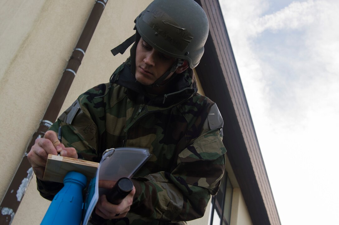 U.S. Air Force Airman 1st Class Kenneth Overfelt, 52nd Maintenance Support Squadron F-16 Phase Support team member, checks M8 chemical agent detection paper for contamination during an exercise at Spangdahlem Air Base, Germany, Sept. 11, 2018. The week-long exercise stressed the importance of readiness in a chemical, biological, radiological, or nuclear contaminated setting. (U.S. Air Force photo by Airman 1st Class Valerie Seelye)