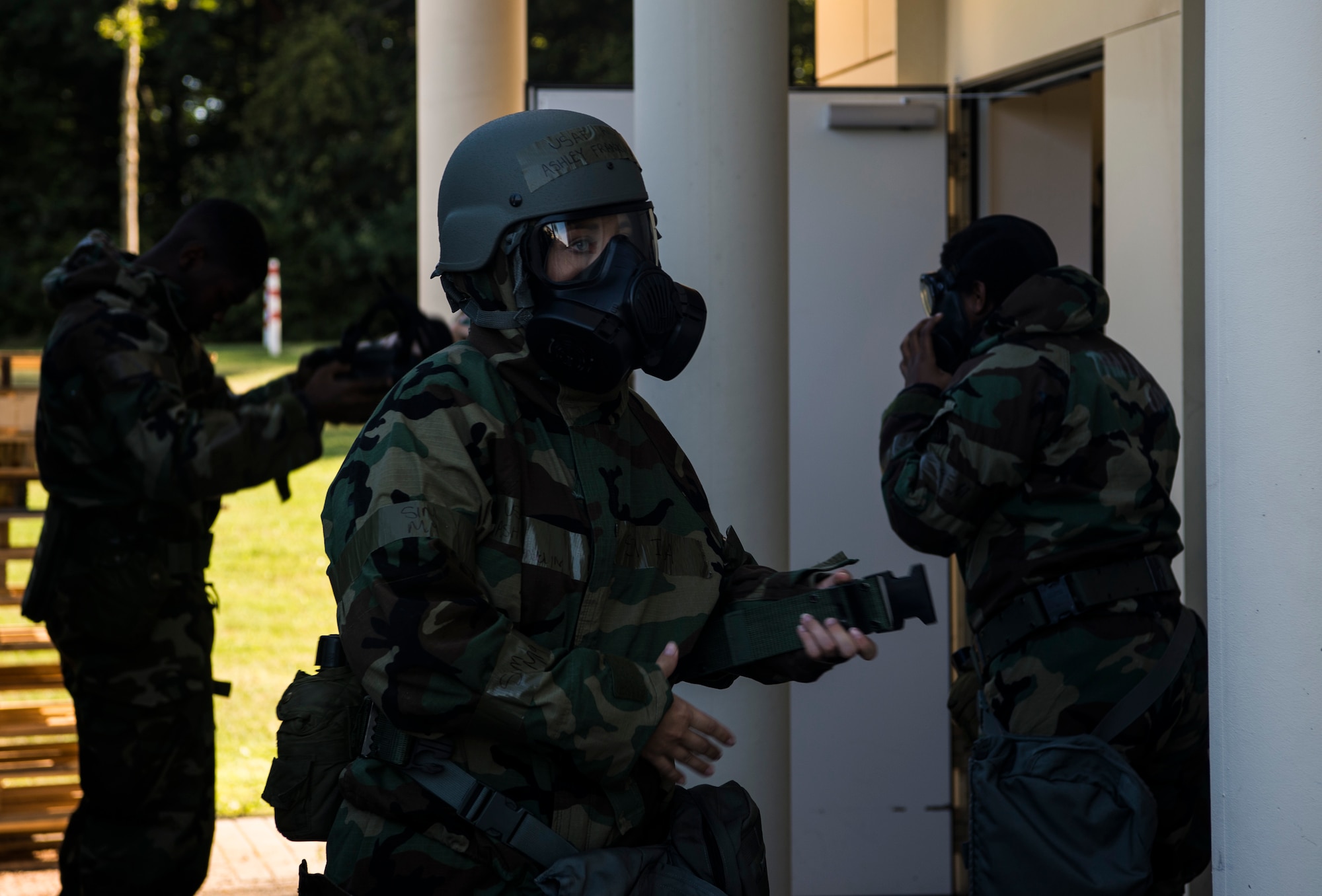 U.S. Air Force Airman 1st Class Ashley Franklin, 52nd Dental Squadron dental assistant, and teammates, remove mission-oriented protective posture gear at Spangdahlem Air Base, Germany, Sept. 12, 2018, during a base-wide readiness exercise. Franklin was part of a simulated decontamination team. The exercise stressed the ability to quickly respond to scenarios to prepare for potential real-life threats. (U.S. Air Force photo by Airman 1st Class Valerie Seelye)