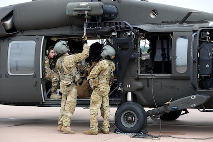 Sgt. Kelby Shifflett, center, and Sgt. Anthony McCall, right, UH-60 Black Hawk crew chiefs, assigned to Charlie Company, 1-169 General Support Aviation Battalion, Oklahoma Army National Guard, conduct pre-flight checks on the external rescue hoist prior to leaving to support relief efforts for Hurricane Florence Sept. 13, 2018. Seven Soldiers from the aviation unit trained in Helicopter Search and Rescue operations will conduct swift water rescues using dynamic and static hoists to rescue stranded citizens after the hurricane subsides.