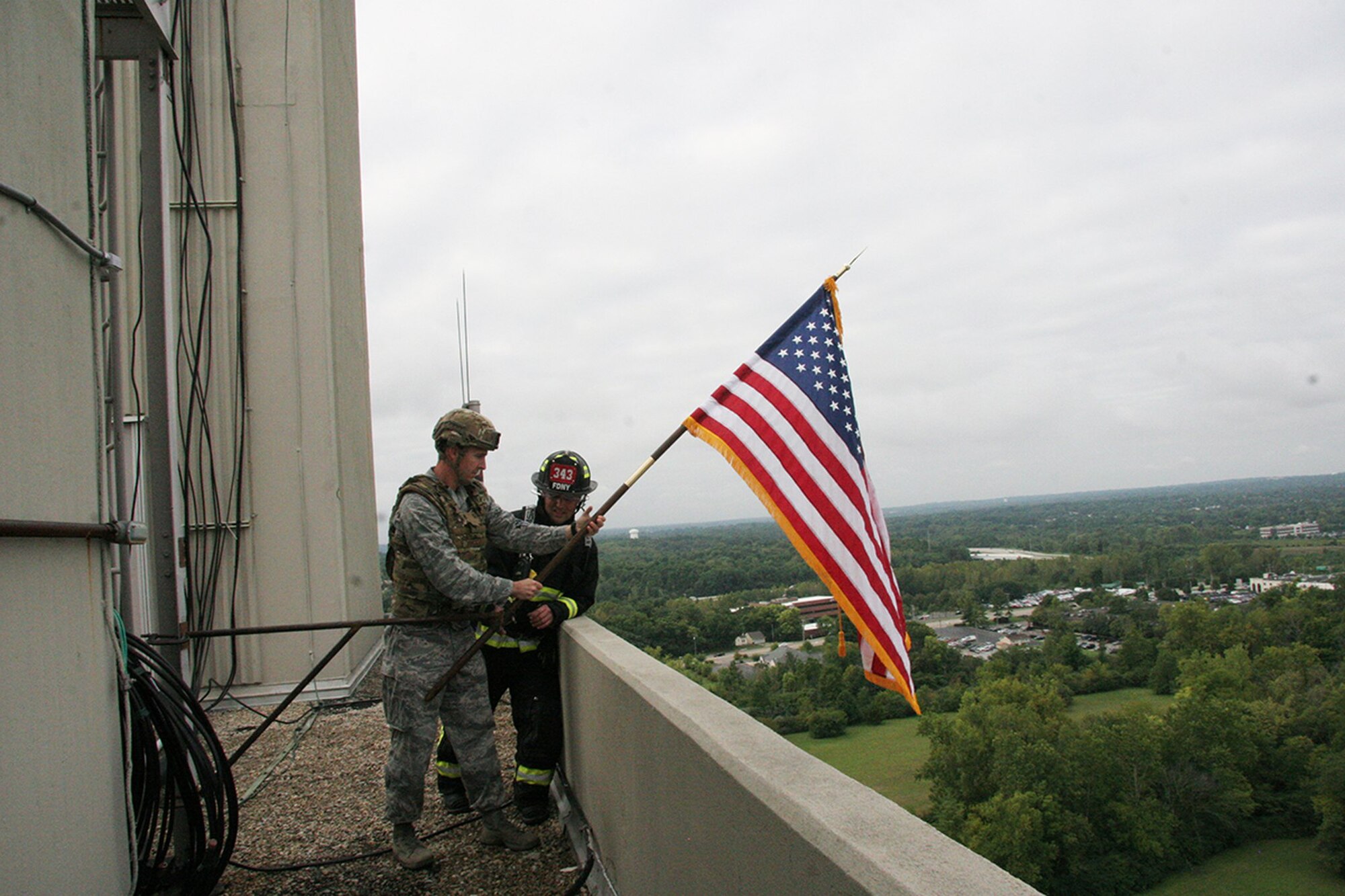 Maj. Tyler Johnson, 788th Civil Engineer Squadron commander, and Chief Jacob King of the Wright-Patterson AFB Fire Emergency Services Department, post the flag during Air Force Research Laboratory's Sensors Directorate's fifth annual 9/11 remembrance ceremony Sept. 11, 2018. (U.S. Air Force photo/Tedd Pitts)