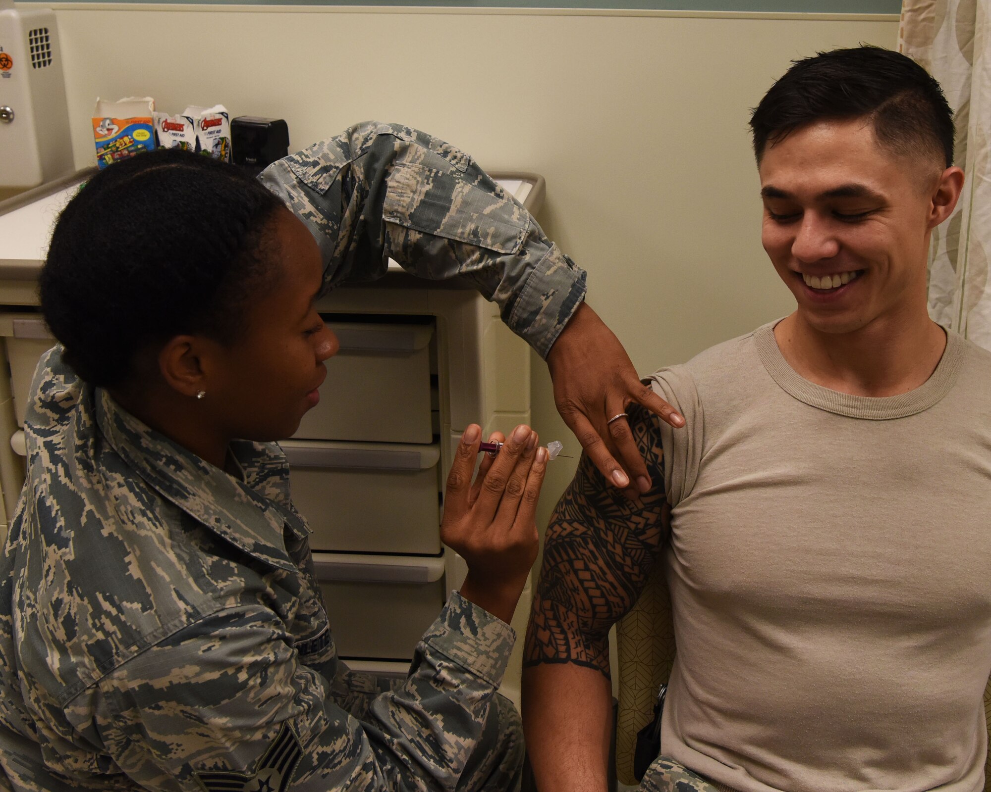 Staff Sgt. Gisele Adanlete-Engram, 56th Medical Group aerospace medical technician, administers a shot to Staff Sgt. Daniel Durbin, 56th MDG Immunizations backup technician, Sept. 13, 2018 at Luke Air Force Base, Ariz.