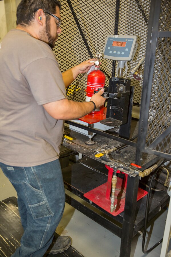 Jose Rivera, heavy mobile equipment mechanic, checks the pressure on a fire bottle cylinder at the production plant aboard Marine Corps Logistics Base Barstow, Calif. Rivera mentioned that although the bottles come in decayed and sometimes damaged, it's his job to ensure a quality product goes back out.