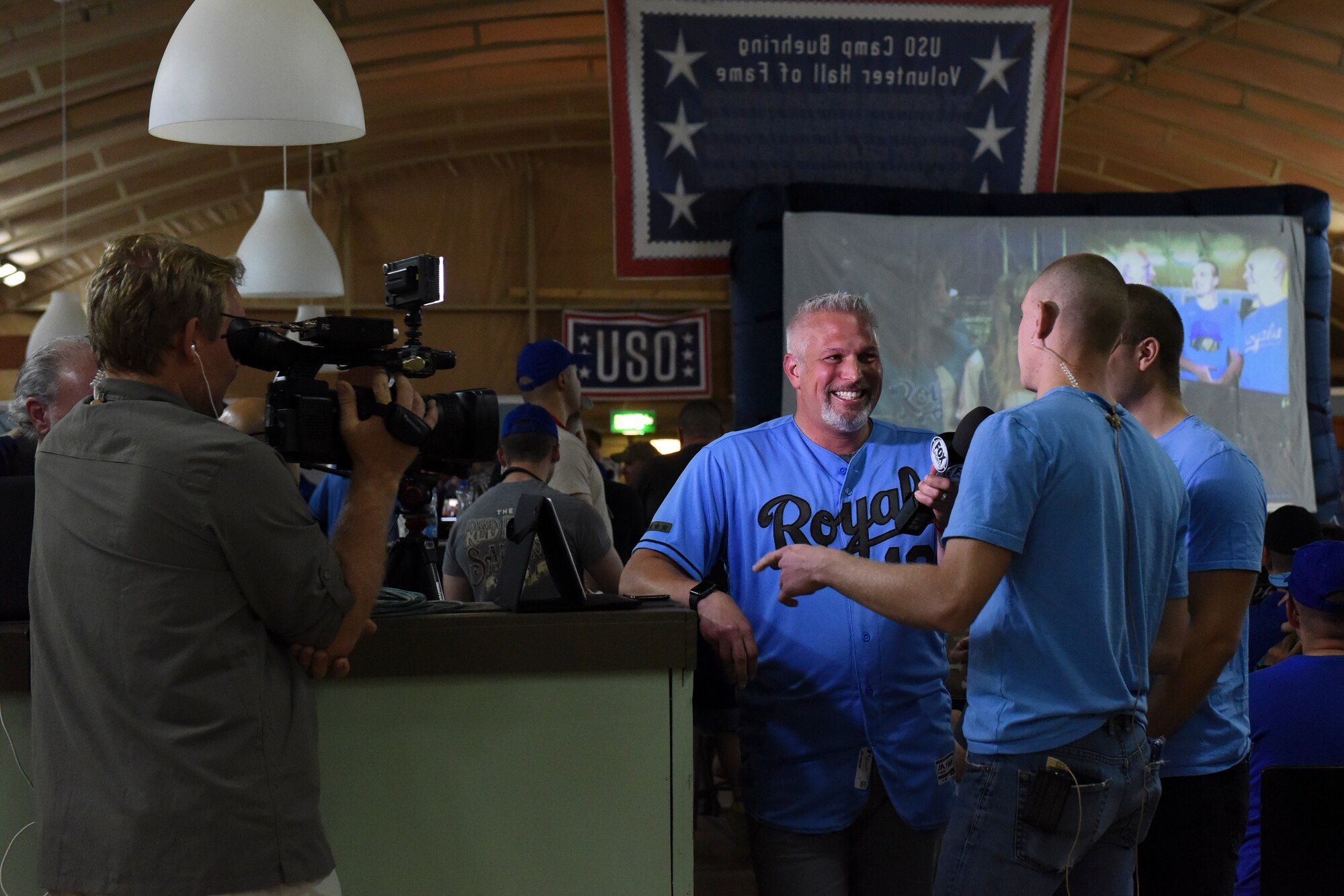Joel Goldberg, FOX Sport Kansas City Royals reporter and host, speaks with service members during a live-stream game Sept. 12, 2018, at Camp Buehring, Kuwait. Some of the fans had the opportunity to speak with their families during a live televised broadcast while deployed overseas. (U.S. Air Force photo by Tech. Sgt. Caleb Pierce)