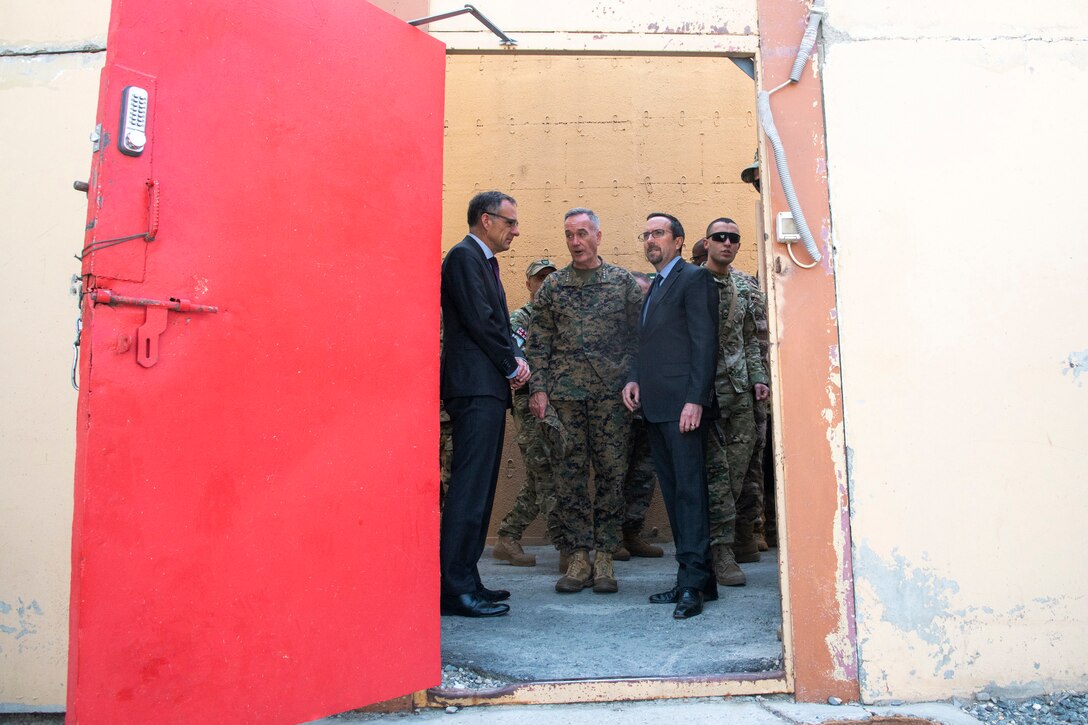 Marine Corps Gen. Joe Dunford and other officials stand by a red door.