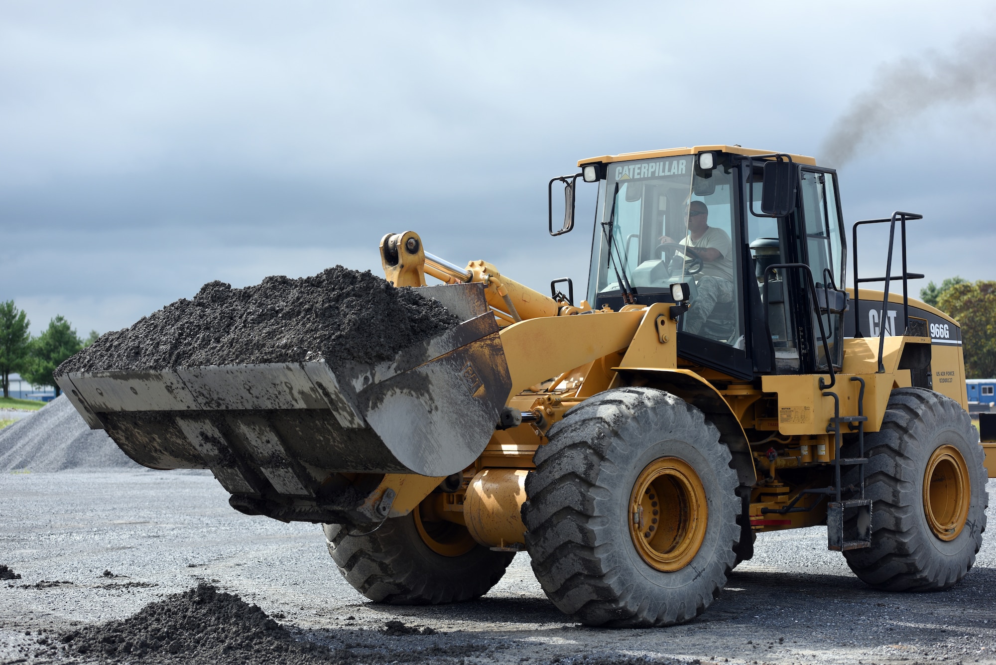 Staff Sgt. Jake Everett, a heavy equipment operator with the 201st RED HORSE Squadron, Fort Indiantown Gap, Pennsylvania, participates in a field training exercise Sept. 7, 2018. Everett was in charge of moving stone that would eventually be used for and laid as a pad for a K-span building. (U.S. Air National Guard photo by Senior Airman Julia Sorber/Released)