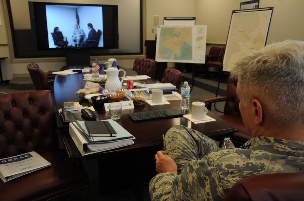Air Force senior leader watching a virtual interaction of an Airman and two civilians