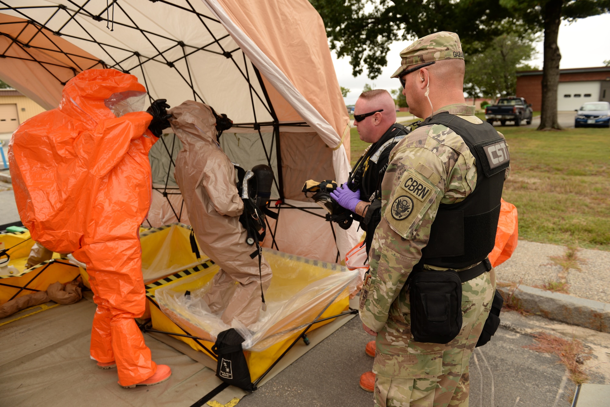 Sgt. Jeffery Garand, and Staff Sgt. David Turner, New Hampshire National Guard 12th Civil Support Team, observe the decontamination of Sgt. David Fostier, center, as part of an external evaluation of the 12th CST’s overall mission readiness, Sept. 11, 2018, at Pease Air National Guard Base, N.H. The 12th CST includes 22 N.H. National Guard airmen and soldiers who are ready to mobilize within one hour. The team is designed to detect weapons of mass destruction, specializing in the detection of chemical, nuclear, biological and explosive agents. (Photo by Master Sgt. Thomas Johnson, 157th ARW Public Affairs)